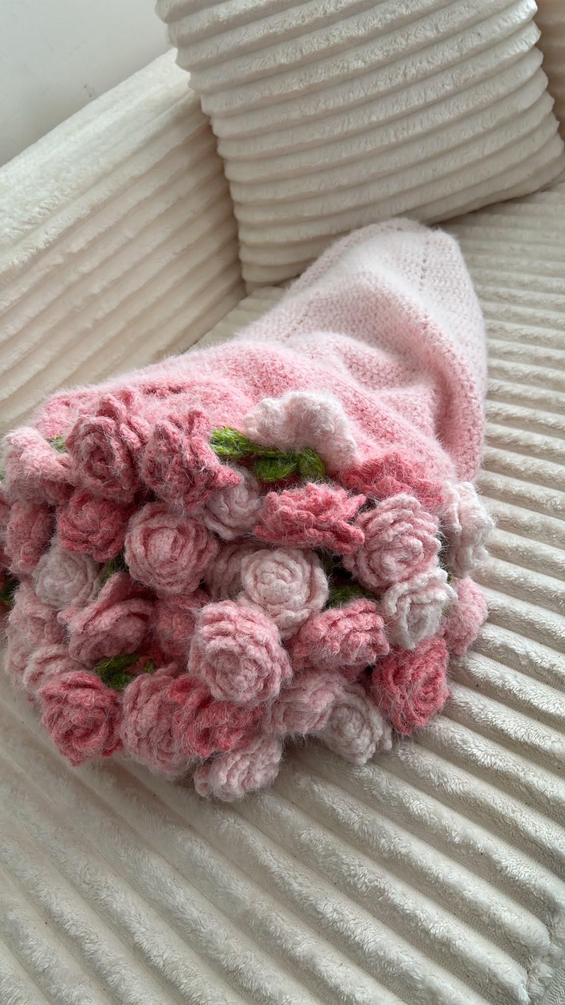 Plaid-bouquet rose déplié sur canapé